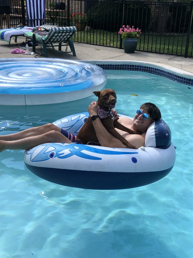 richard hanging out with a dog in a pool